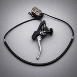 Sur-Ron Ultra Bee OEM hydraulic brake lever and caliper on gray background, complete front and rear brake upgrade kit for electric dirt bikes.