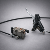 Sur-Ron Ultra OEM hydraulic brake lever and caliper assembly on gray background — front or rear replacement brake kit